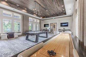 A modern living room with a long wooden table and a television.